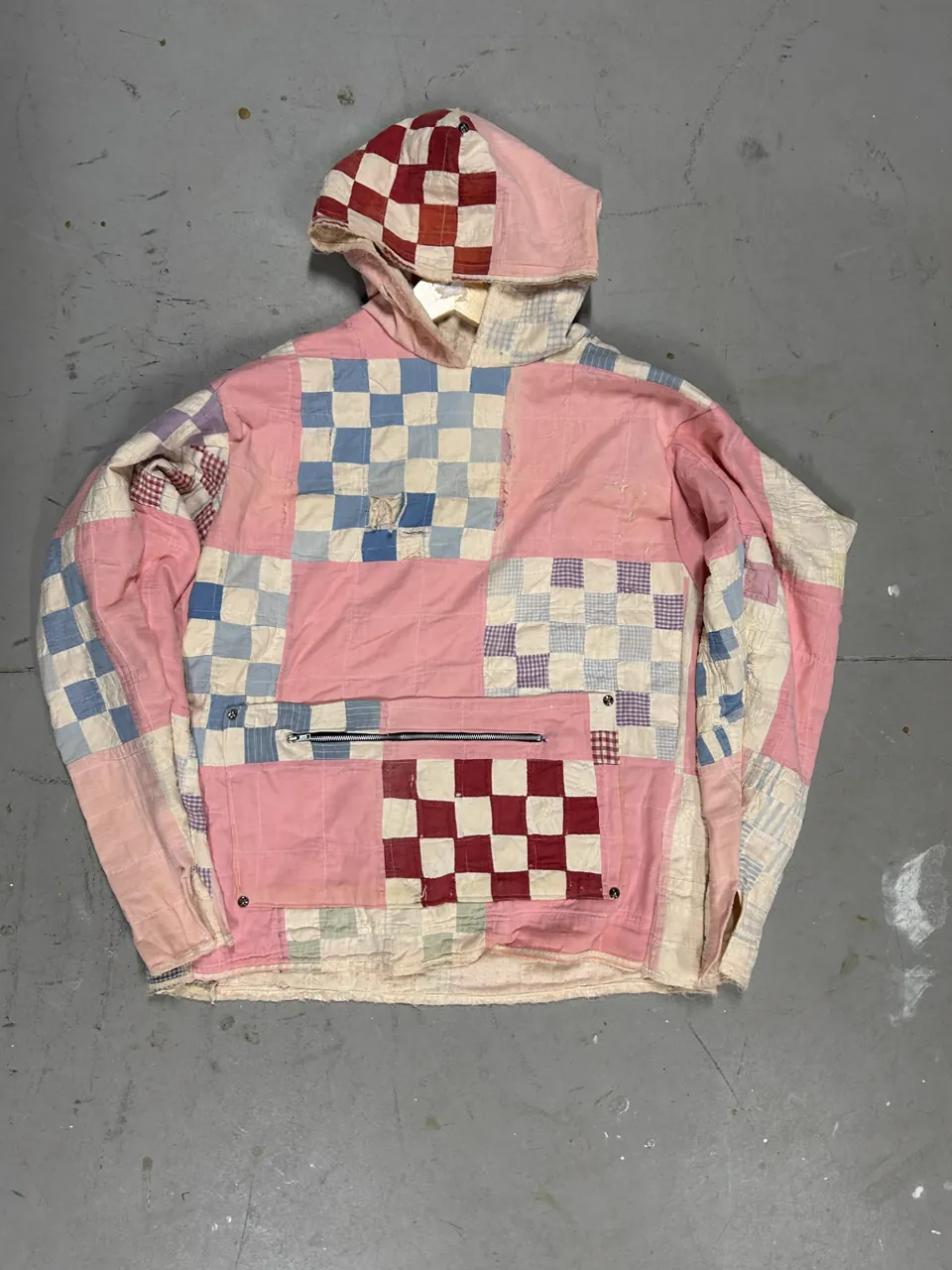 Pullover hoodie cut from a pink, red, and blue checkerboard patchwork quilt