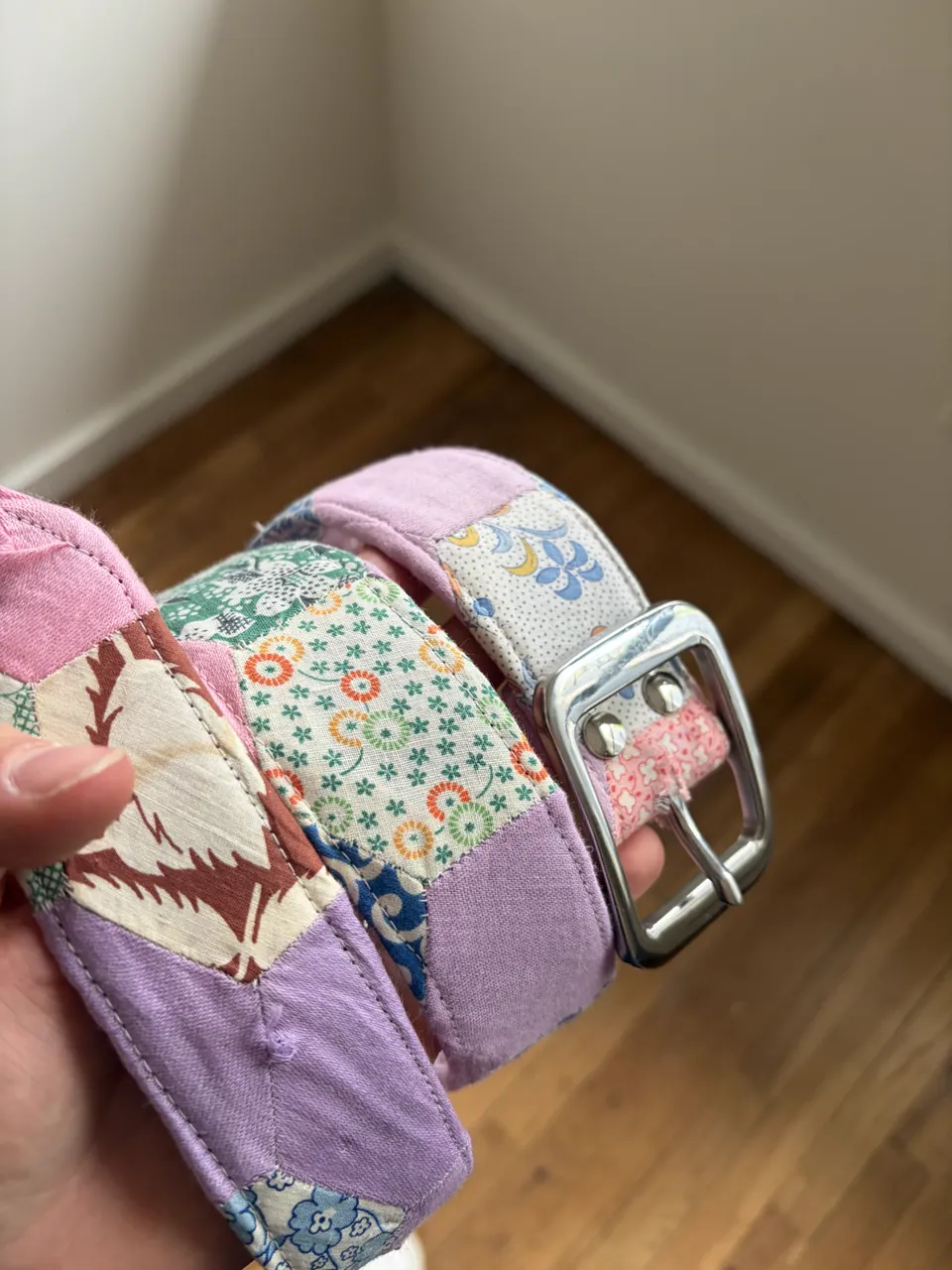 Belt pieced from lilac, green, and floral quilt scraps with a chrome center-bar buckle